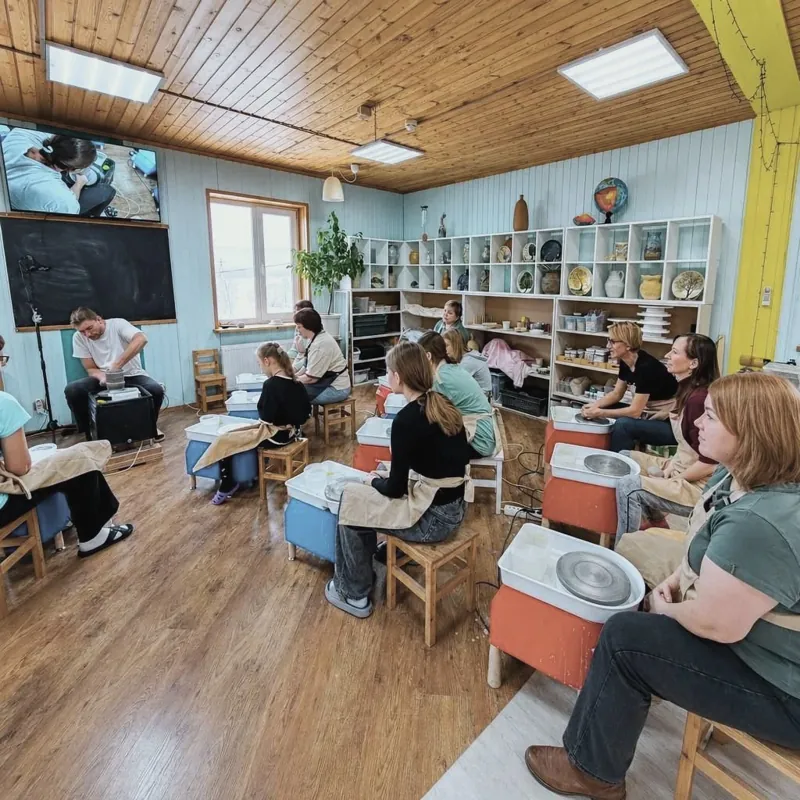 Группа за гончарными кругами, на экране руки мастера